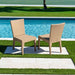 Two wicker chairs by a poolside on a sunny day