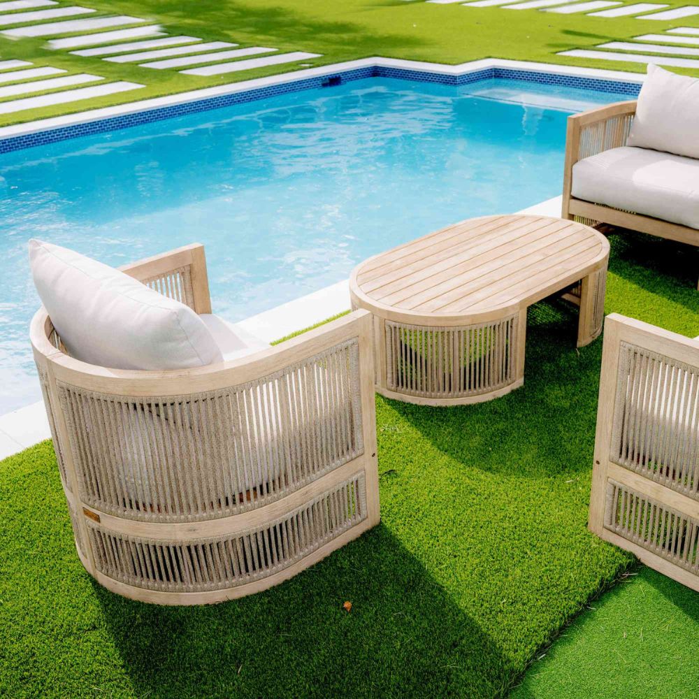 Outdoor furniture set with chairs and a table by a pool