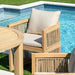Wooden outdoor furniture set with beige cushions by a pool