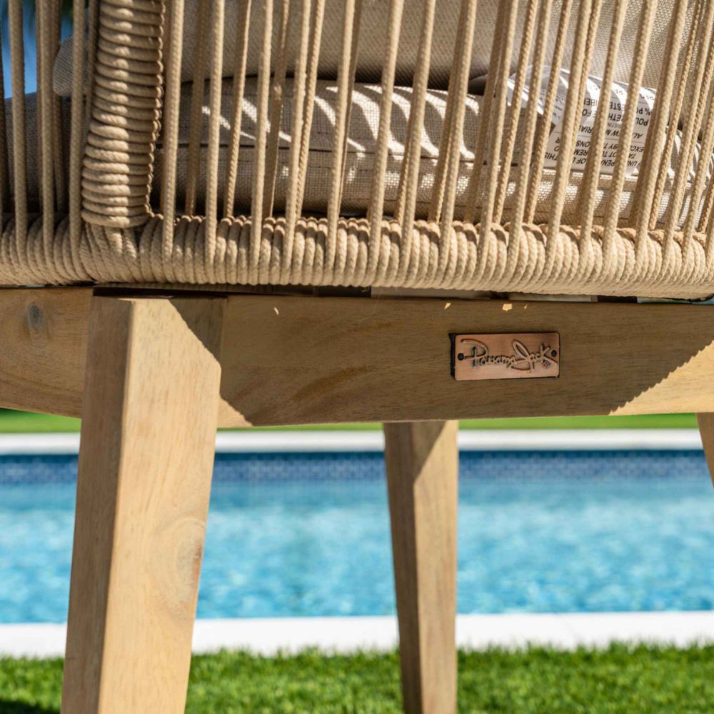 Wicker chair with wooden base by a pool