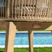 Wicker chair with wooden base by a pool