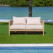 Wooden outdoor sofa with white cushions by a pool and greenery