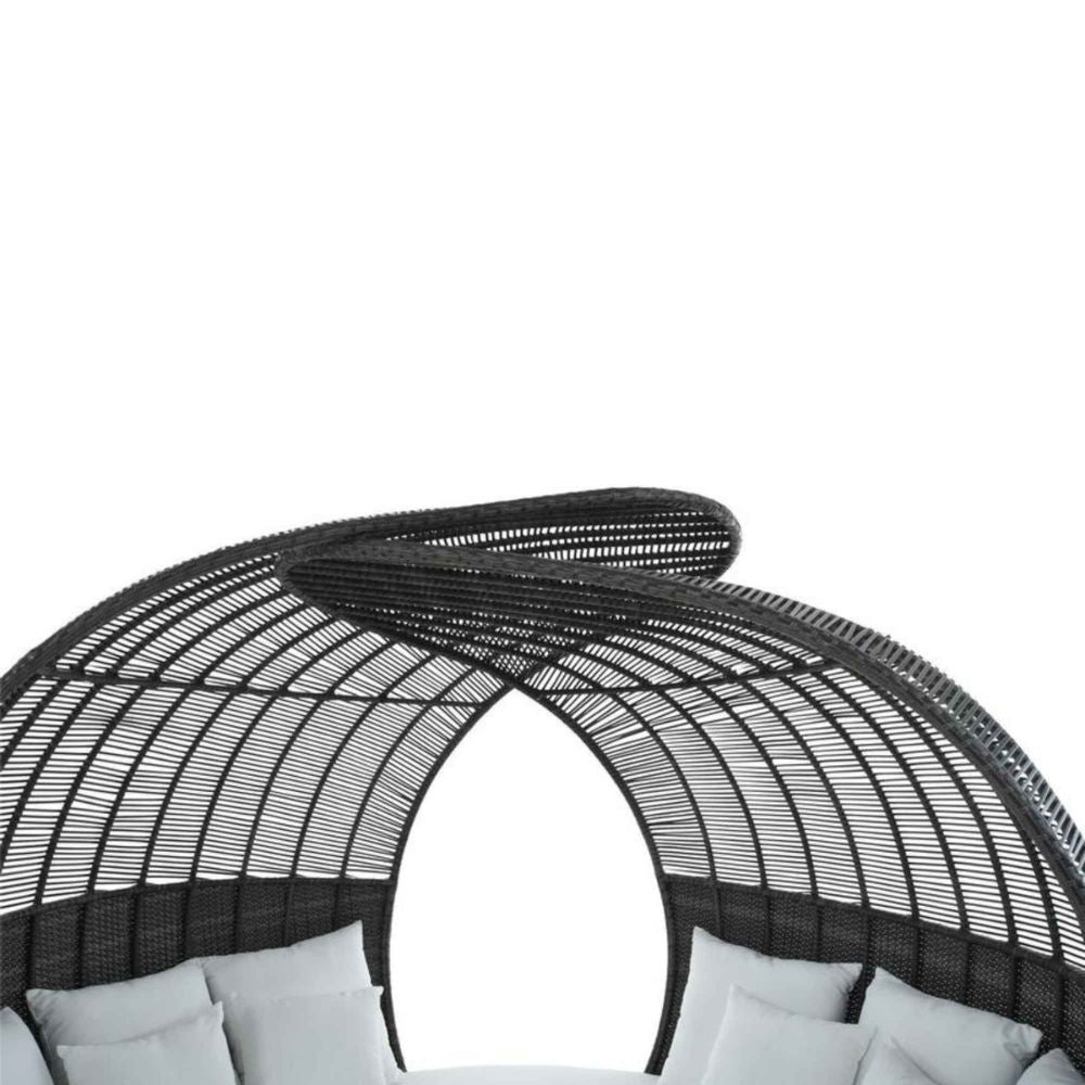 Black wicker outdoor chair with white cushions on a white background