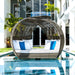 Wicker daybed with white and blue cushions by a poolside