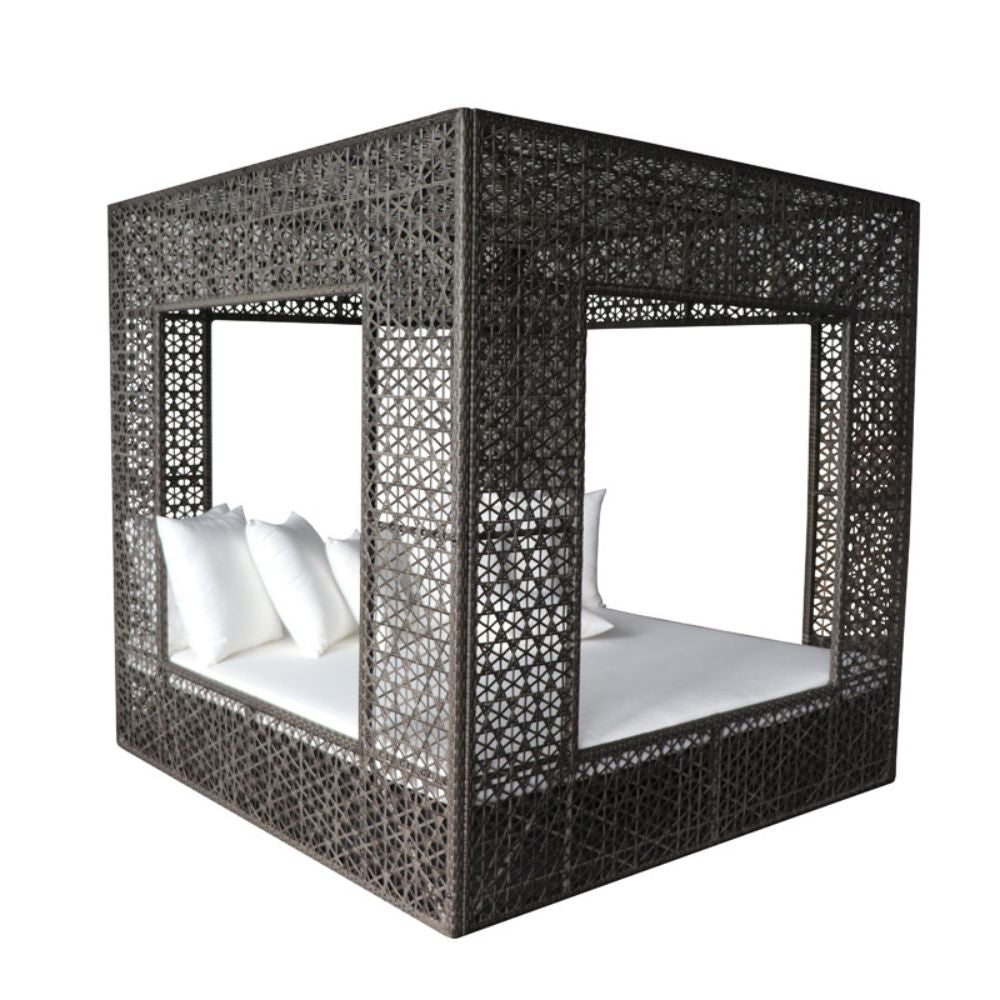Black woven canopy bed with white bedding on a white background