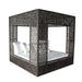 Black woven canopy bed with white bedding on a white background