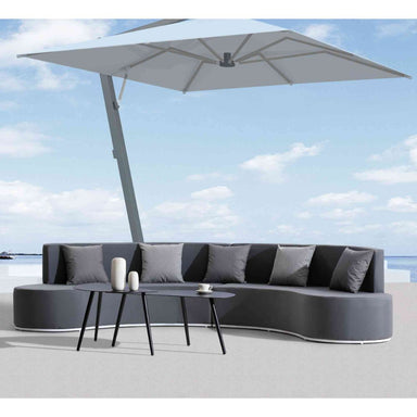 Modern outdoor sofa set with a large umbrella against a blue sky.
