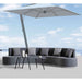 Modern outdoor sofa set with a large umbrella against a blue sky.