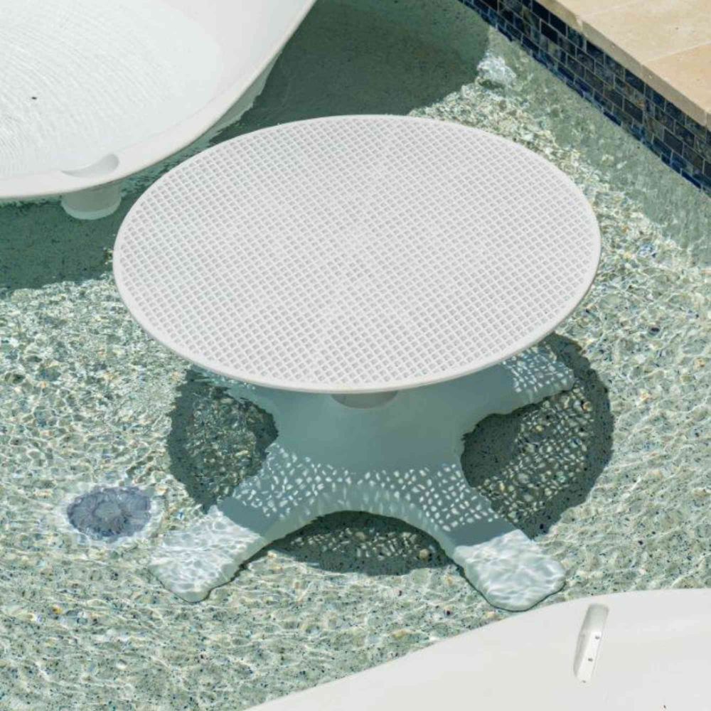 Round white table with textured surface on a pool deck