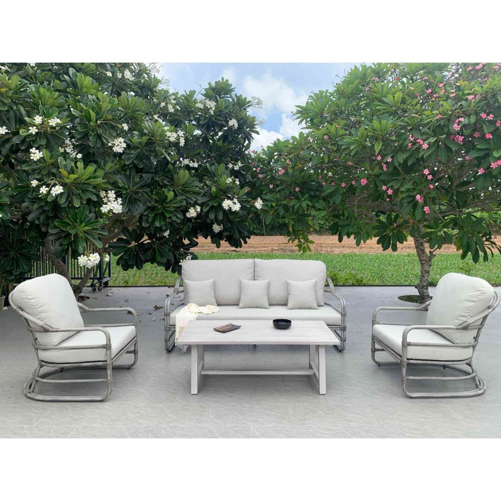Outdoor patio set with white cushions on a wooden deck surrounded by greenery.