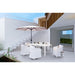 Outdoor patio set with white furniture and a large umbrella on a modern terrace.