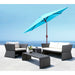 Outdoor patio furniture set with a blue umbrella on a sunny day.