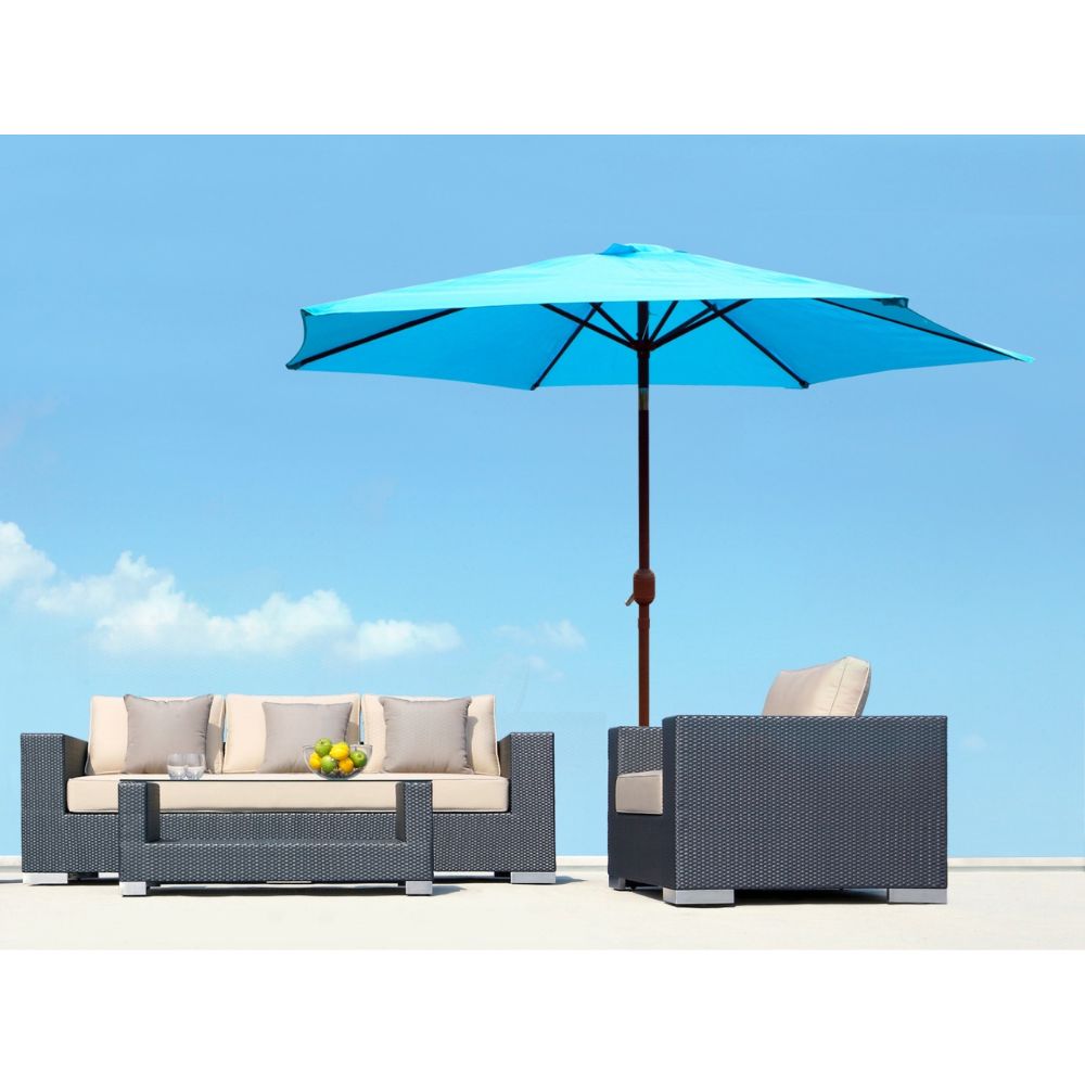 Outdoor patio set with a blue umbrella against a clear blue sky.