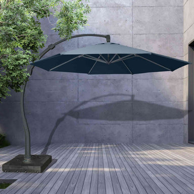 Blue patio umbrella with a stand on a wooden deck against a concrete wall.