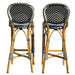 Two bar stools with wicker frames and chevron-patterned seats on a white background