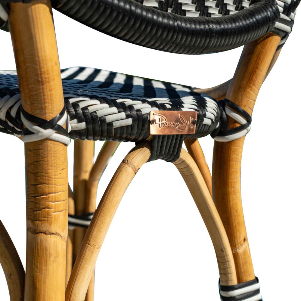 Close-up of a wicker chair with black, white, and blue striped pattern and visible brand logo.
