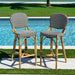 Two bar stools with black and white striped seats by a pool