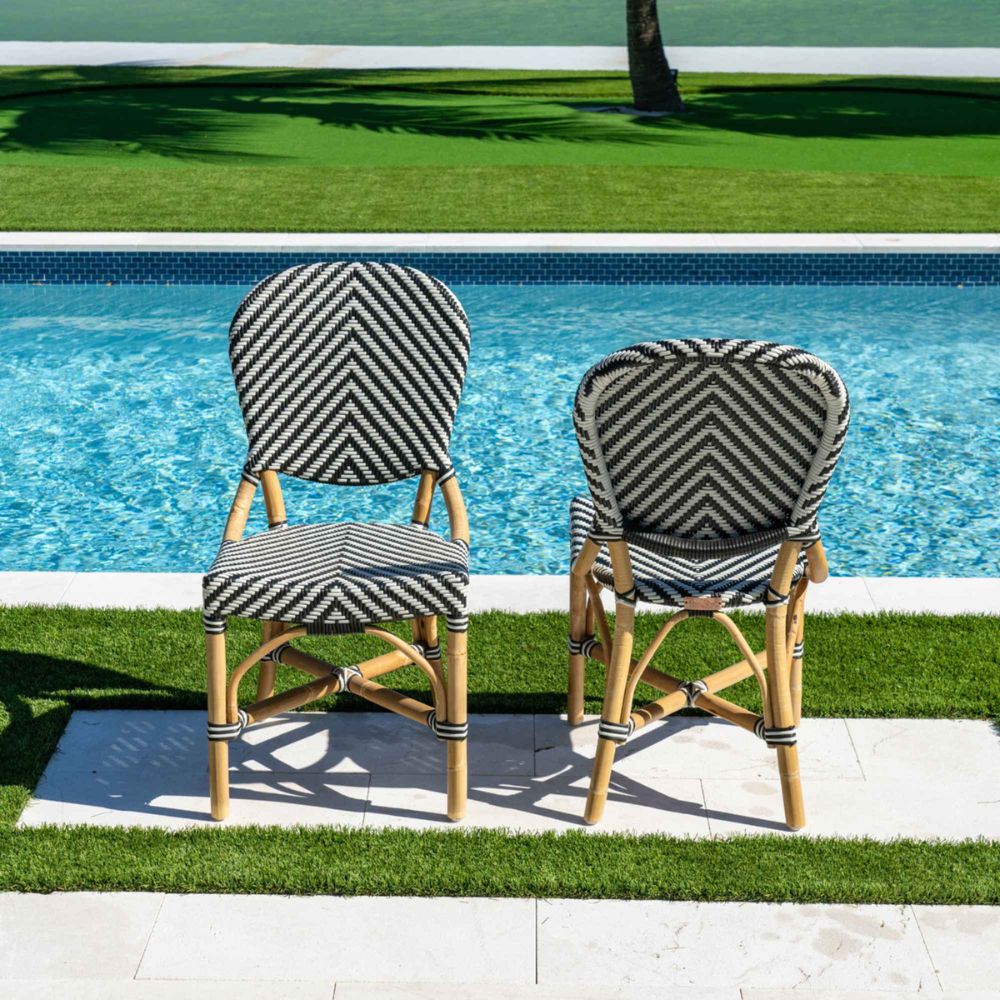 Two striped chairs by a poolside on a sunny day.