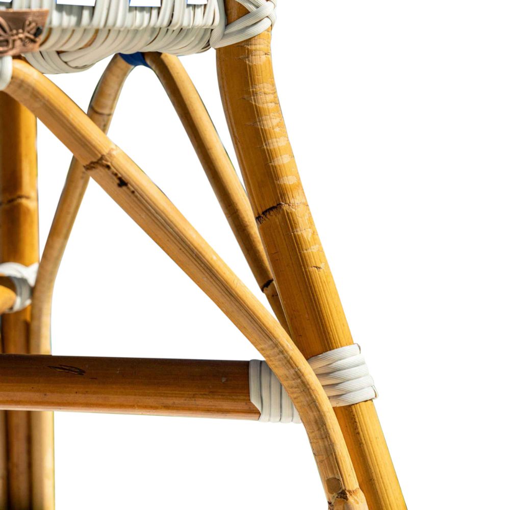 Close-up of a rattan chair with a white cushion on a white background