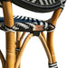 Close-up of a wicker chair with black, white, and blue striped pattern and a visible brand logo.