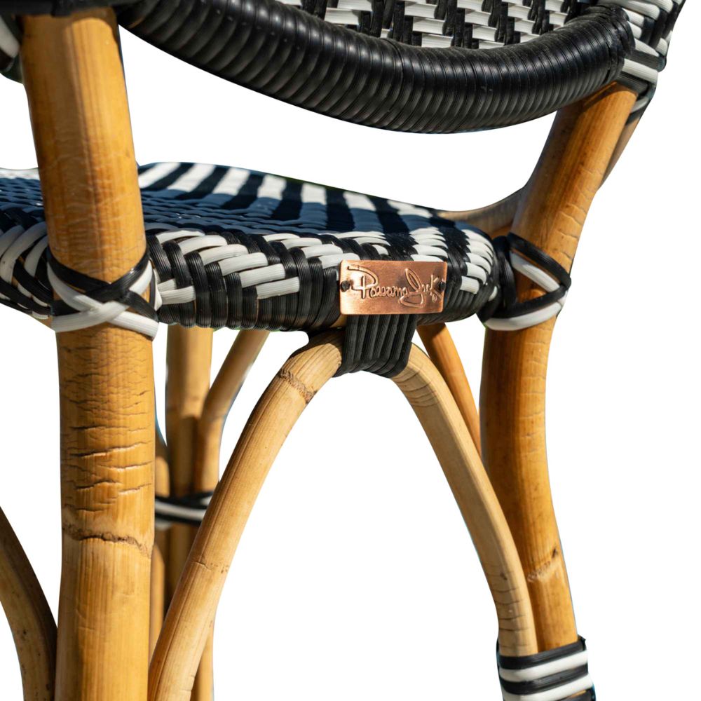 Close-up of a wicker chair with black, white, and blue striped pattern and a visible brand logo.