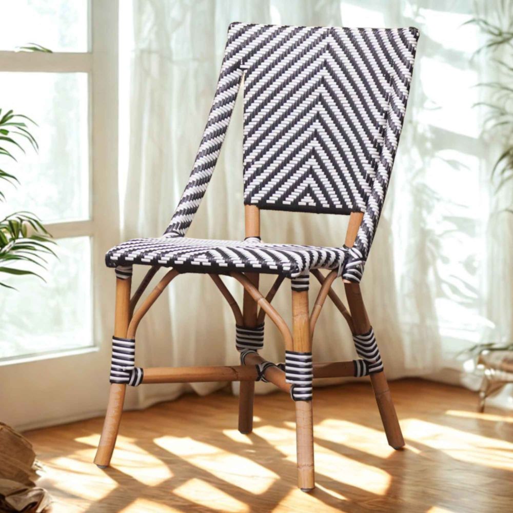 Wooden chair with black and white striped cushion in a bright room with curtains and plants.