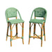 Two green wicker bar stools on a white background