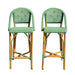 Two green wicker bar stools on a white background