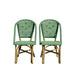 Two green wicker chairs on a white background