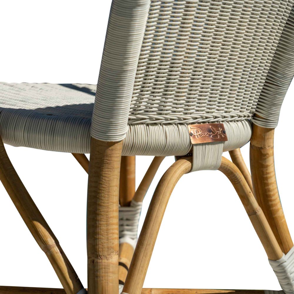 Close-up of a wicker chair with wooden legs on a white background