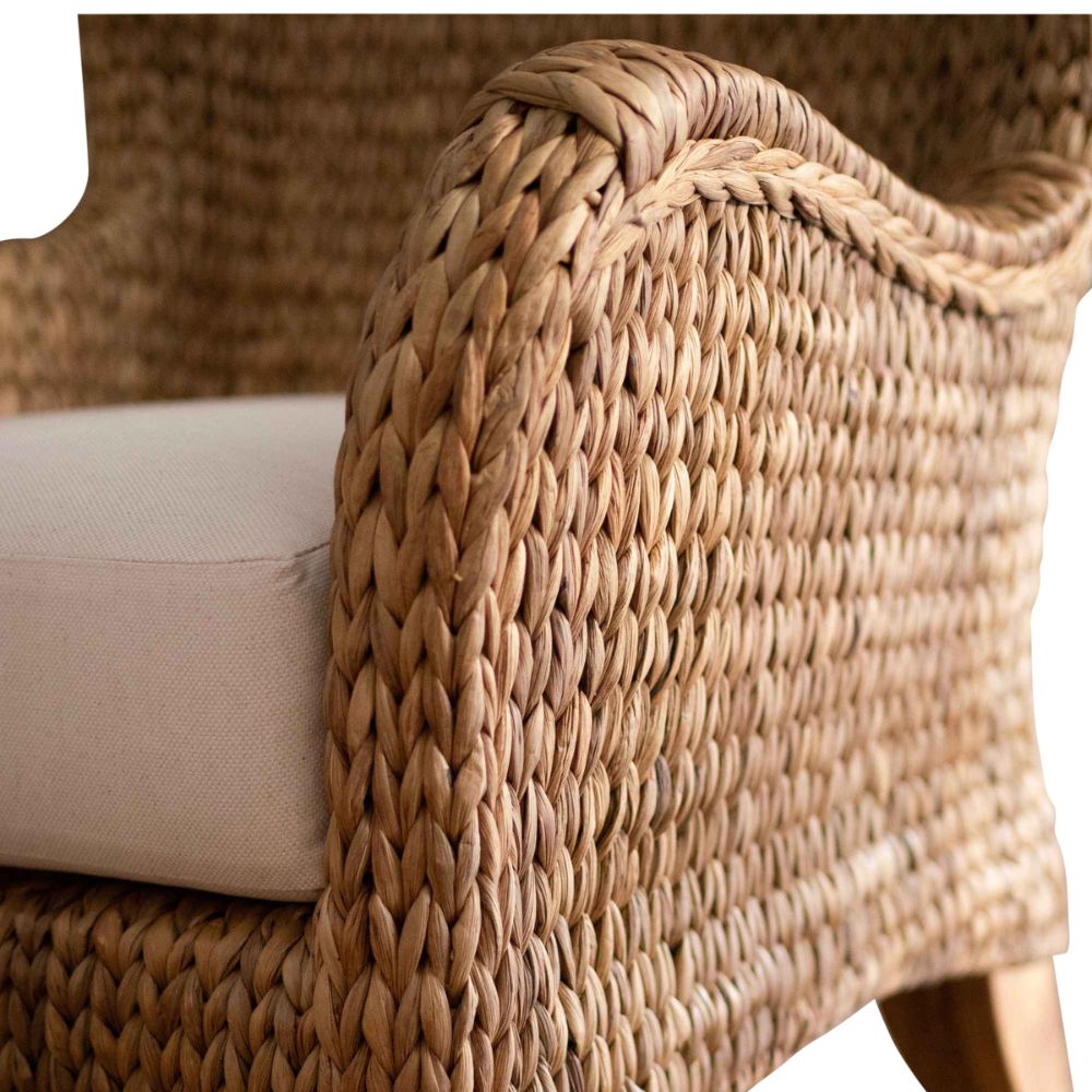 Close-up of a wicker chair with a white cushion on a plain background