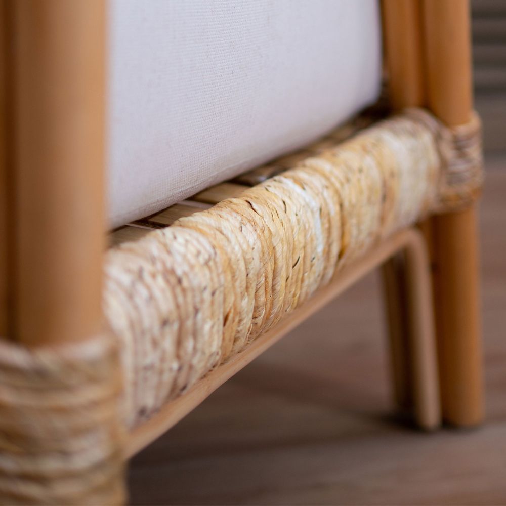 Close-up of a chair with woven backrest and wooden frame.