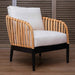Wicker armchair with white cushion on a wooden floor