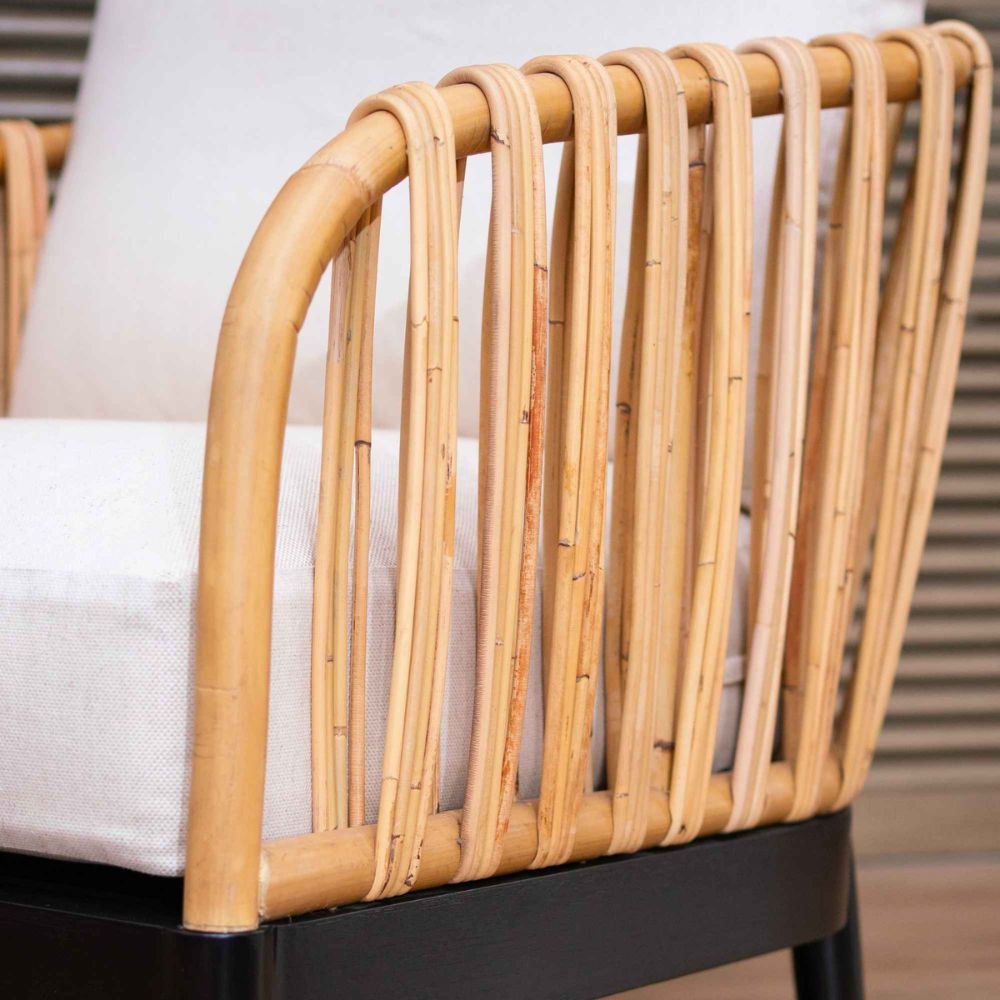 Close-up of a wicker chair with a white cushion on a blurred background