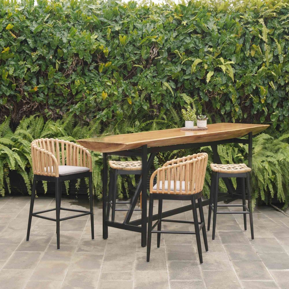 Outdoor dining set with a wooden table and chairs against a green hedge.