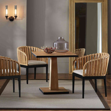 Dining area with wooden table and chairs in a room with a mirror on the wall.
