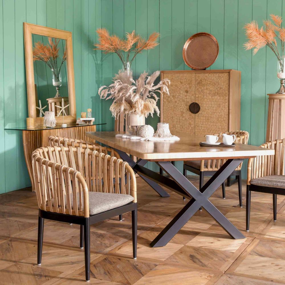 Dining room with wooden table and chairs against a green wall.