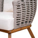Wicker chair with wooden legs and white cushion on a neutral background