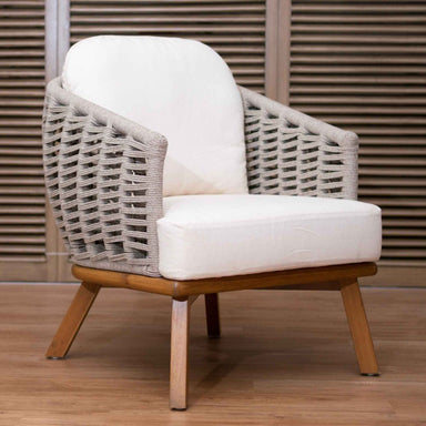 Chair with wicker backrest and wooden legs on a wooden floor.