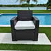 Black wicker chair with white cushion by a poolside