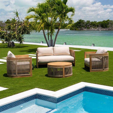 Outdoor patio set with beige cushions by a pool and waterfront