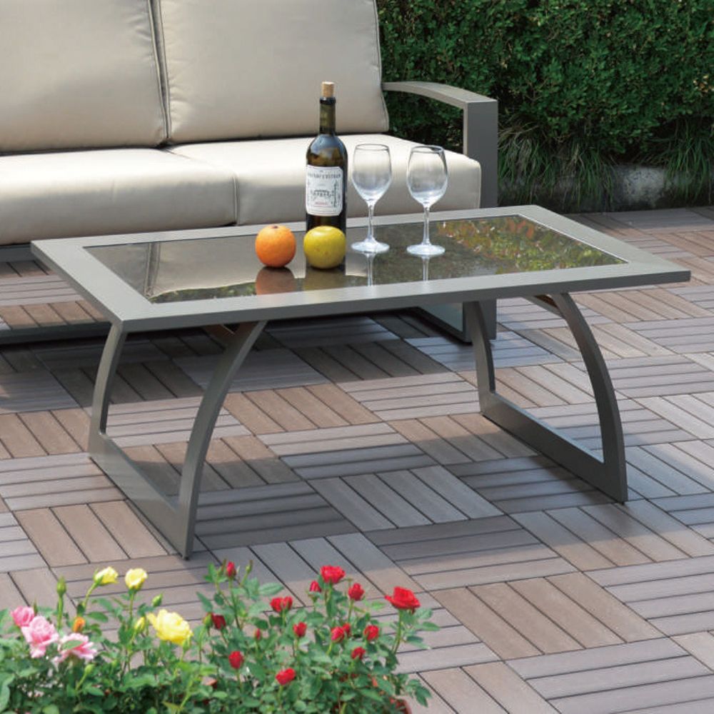 Outdoor patio setting with a table, sofa, and decorative elements on a wooden deck.