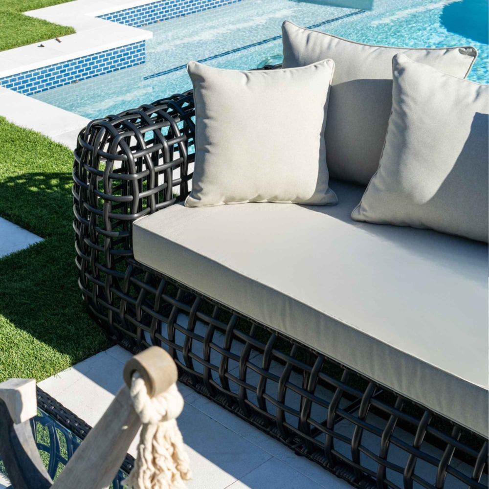 Outdoor sofa with cushions by a poolside