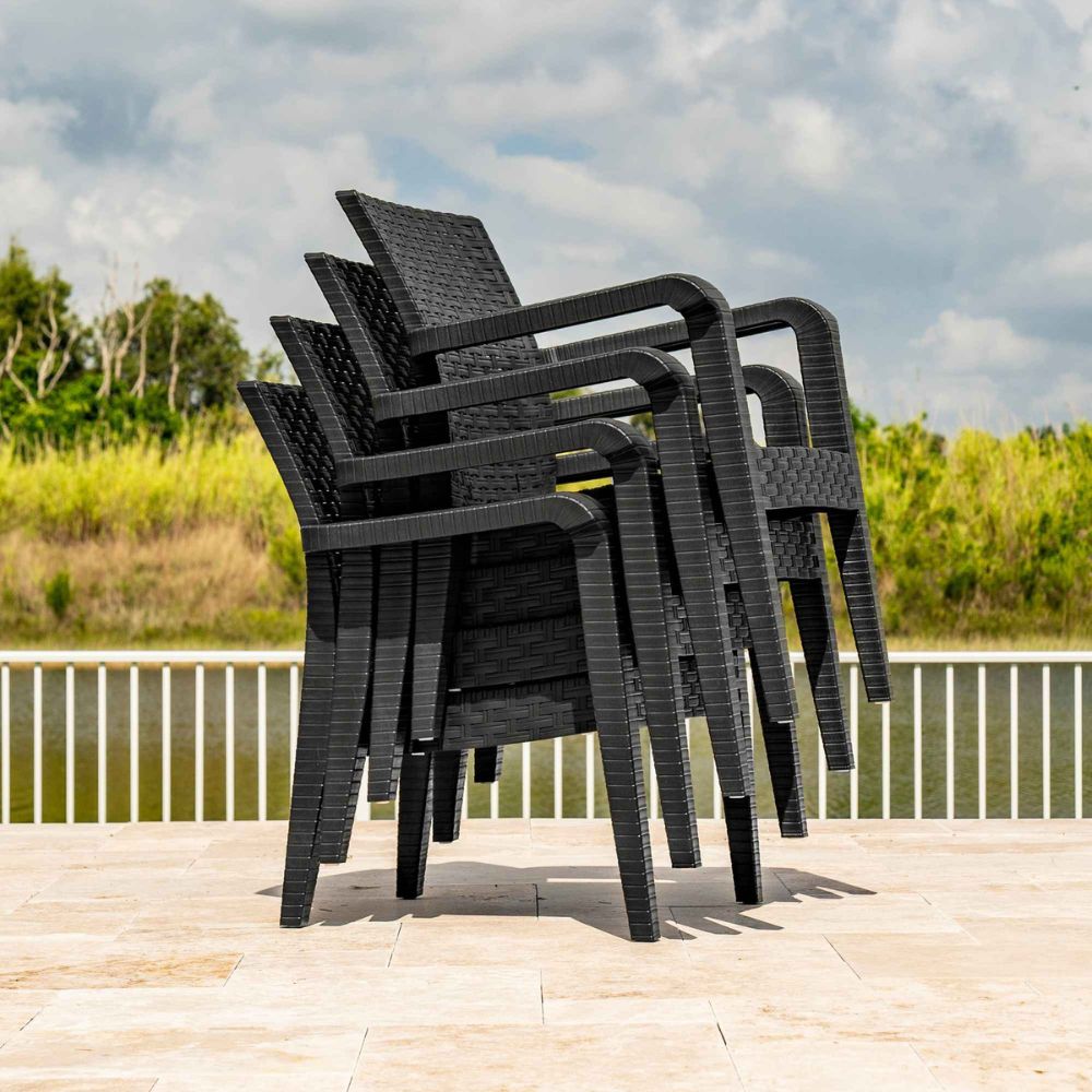 Stack of black outdoor chairs on a wooden deck with a scenic background