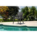 Wicker chair by a pool with greenery in the background