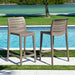 Two outdoor bar stools by a pool with a scenic background