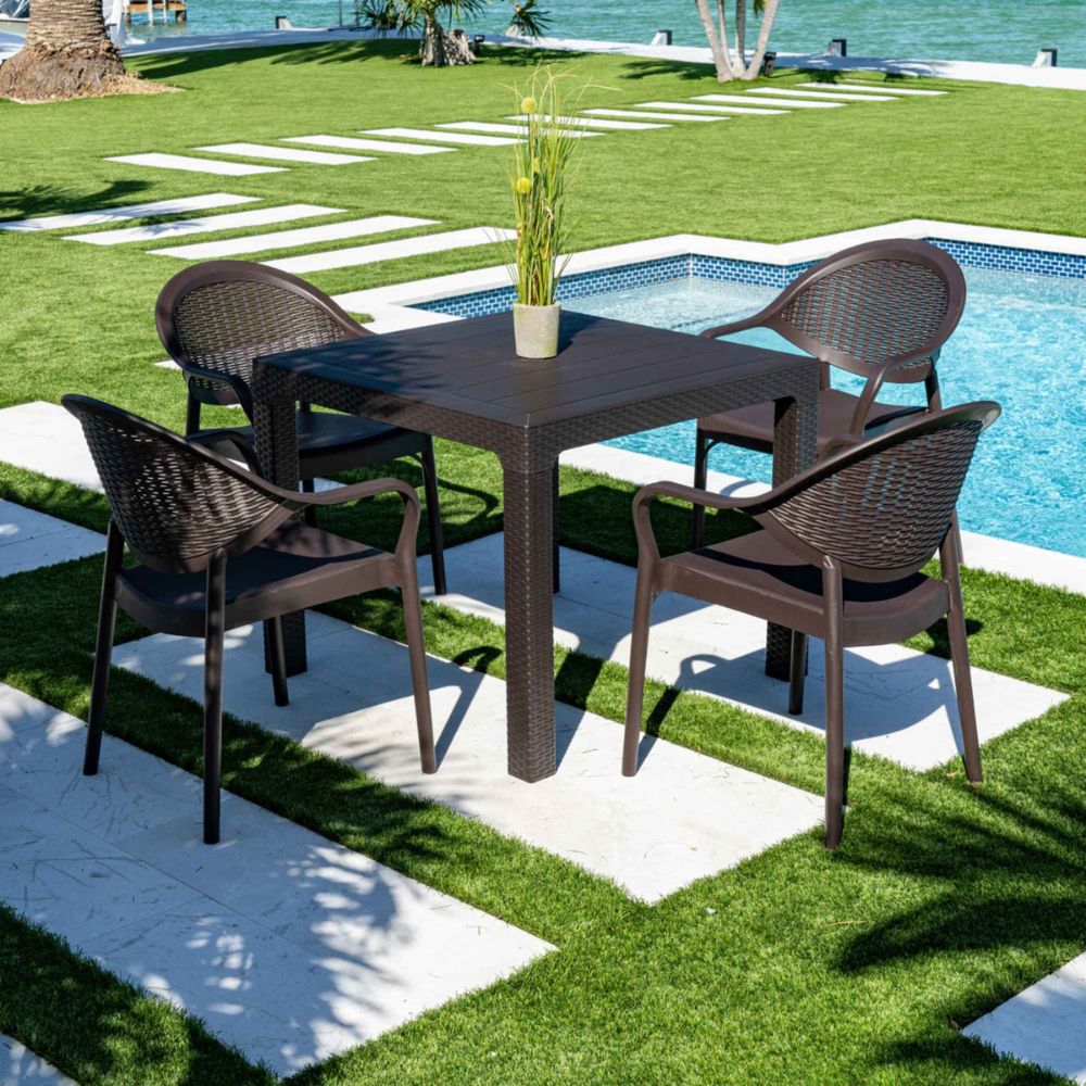 Outdoor patio set with table and chairs by a pool