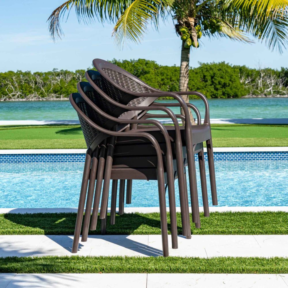 Stack of brown outdoor chairs by a pool with palm trees in the background