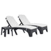 Two black wicker lounge chairs with white cushions on a white background