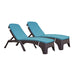 Two blue cushioned lounge chairs with wicker frames on a white background